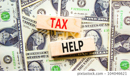 Tax help symbol. Concept words Tax help on wooden blocks on a beautiful background from dollar bills. Dollar bills. Business, support and tax help concept. Copy space. 104046621