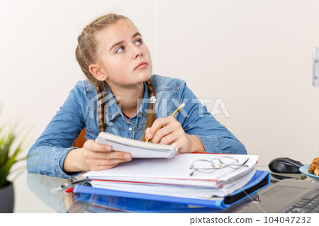 Girl doing her homework with laptop 104047232