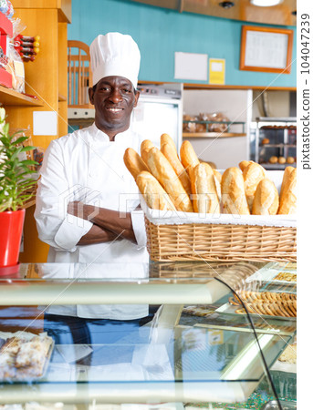 Proud owner of bakery shop wearing white uniform Proud owner of bakery shop wearing white uniform 104047239