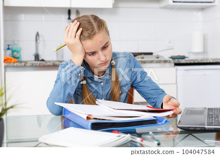 Girl tired of doing her homework 104047584