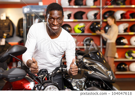 Nice Afro American man posing near motorcycle Nice Afro American man posing near motorcycle 104047618