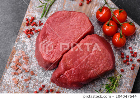 Raw beef eye steak round with salt, spices and herbs Raw beef eye steak round with salt, spices and herbs 104047644