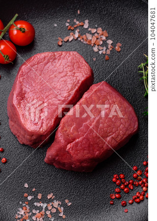Raw beef eye steak round with salt, spices and herbs Raw beef eye steak round with salt, spices and herbs 104047681