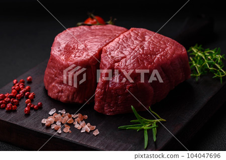 Raw beef eye steak round with salt, spices and herbs 104047696