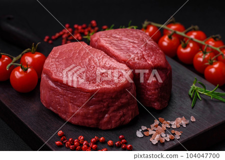 Raw beef eye steak round with salt, spices and herbs 104047700