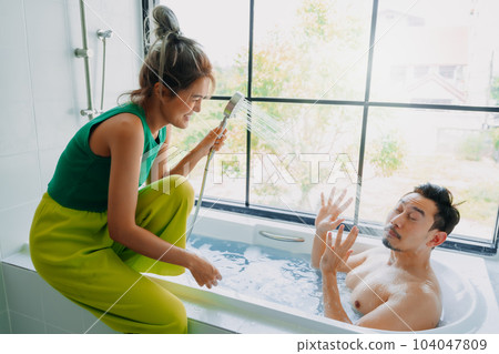 Funny playful asian couple lover play in the bathtub in the bathroom. 104047809