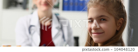 Portrait of child girl winks at camera in doctor office Portrait of child girl winks at camera in doctor office 104048120