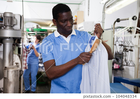 Man working in dry cleaner 104048334