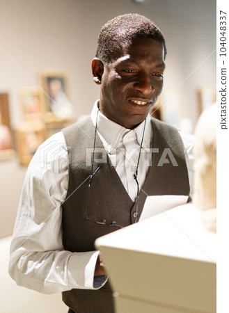 African man looking at exhibit 104048337