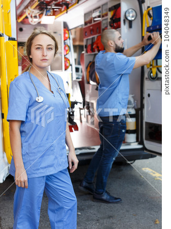 Cross-armed female emergency doctor 104048349