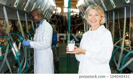 Woman with glass of milk on farm Woman with glass of milk on farm 104048431
