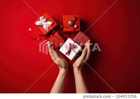 Women's hands give a gift on a red background, the concept of Christmas  Women's hands give a gift on a red background, the concept of Christmas  104053356