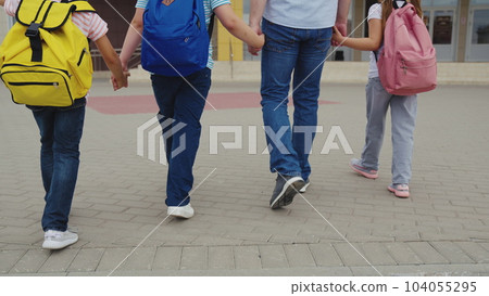 father with many children takes children school with backpacks. group children climb school stairs with briefcase their back. group children go hand hand school. friendly happy family team. student . father with many children takes children school with backpacks. group children climb school stairs with briefcase their back. group children go hand hand school. friendly happy family team. student . 104055295