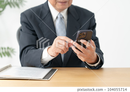 操作智能手機的老人 104055714