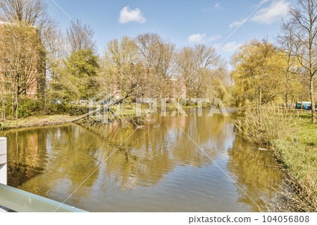 a river with trees and houses in the background, taken from a boat on the water's edge as it passes by 104056808