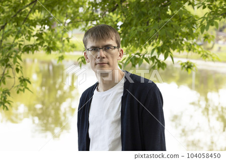 Portrait Of Tall Fit Blond 40 Yo Male In Eyesight Glasses, Smiling Looking At Camera, Green Tree And Lake On Background. Horizontal Plane 104058450