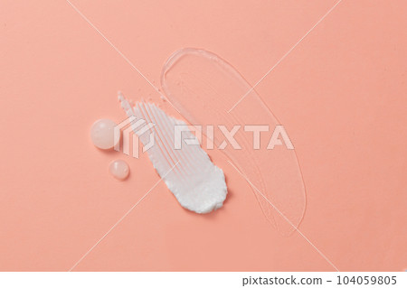 Against the pink background, three textures with the liquid texture of gels, serums and moisturizers decorated. Creative background with blank space for advertising.  104059805