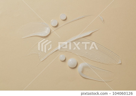 Smooth liquid substance of lotion, organic body milk. Face cream, body moisturizer, hair conditioner smear smudge stroke on beige background 104060126