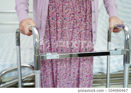 Asian elderly woman disability patient walk with walker in nursing hospital, medical concept. Asian elderly woman disability patient walk with walker in nursing hospital, medical concept. 104060467