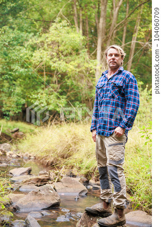 Australian man standing near a stream in the forest Australian man standing near a stream in the forest 104060709