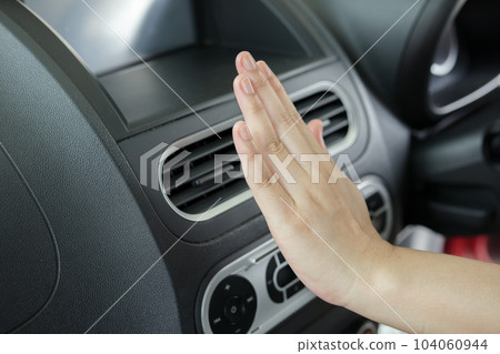 hand checking air conditioner system inside the car 104060944