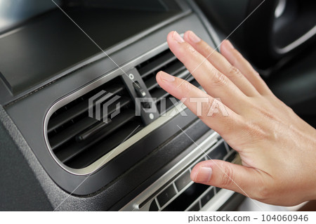 hand checking air conditioner system inside the car 104060946