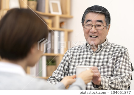 Senior man receiving tea from a caregiver Rehydration Senior man receiving tea from a caregiver Rehydration 104061877