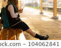 A high school girl sitting on a bench in the home where the setting sun shines 104062841