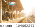 A high school girl waiting for a train on a platform where the setting sun shines 104062843