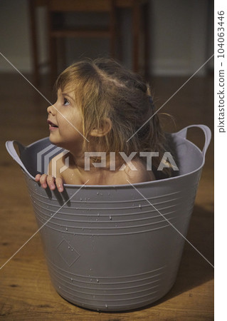 Charming child bathes in a small bathroom in the evening 104063446