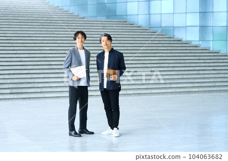 Casually dressed businessmen lined up at the office entrance 104063682
