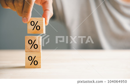 Concept of interest rate and financial rates. Hand placing a wooden cube block on top, symbolizing an increasing trend, with an upward direction icon and percentage symbol. Concept of interest rate and financial rates. Hand placing a wooden cube block on top, symbolizing an increasing trend, with an upward direction icon and percentage symbol. 104064950