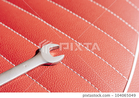 a wrench on the leather seat of a motorcycle during repair a wrench on the leather seat of a motorcycle during repair 104065049