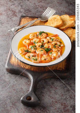 Spanish Garlic Shrimp Gambas al Ajillo closeup on the plate served with toasts. Vertical Spanish Garlic Shrimp Gambas al Ajillo closeup on the plate served with toasts. Vertical 104065343