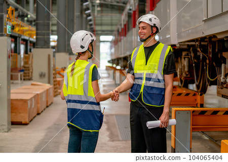 Engineer or factory technician worker man and woman shake hands for the success of joined project 104065404
