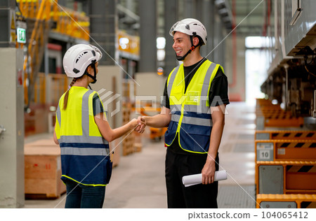 Engineer or factory technician worker man and woman shake hands for the success of joined project 104065412