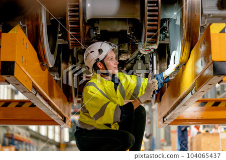 Technician or train factory worker hold light stick to check and fix problem under electric train Technician or train factory worker hold light stick to check and fix problem under electric train 104065437