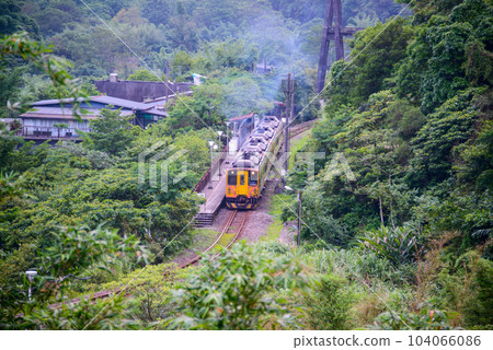 A yellow diesel train stops next to the platform of Lingjiao Station. 104066086