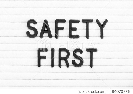 Black color letter in word safety first on white felt board background Black color letter in word safety first on white felt board background 104070776
