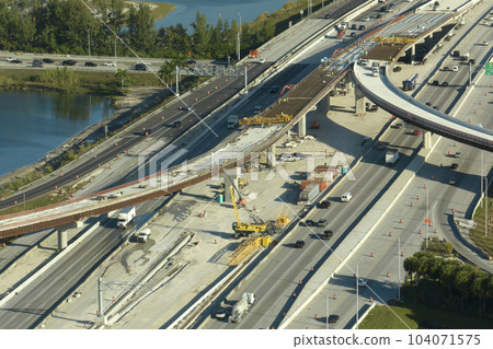 Construction roadworks on american transport infrastructure. Renovation of highway road interchange with moving traffic in Miami, Florida. Development of interstate transportation concept 104071575