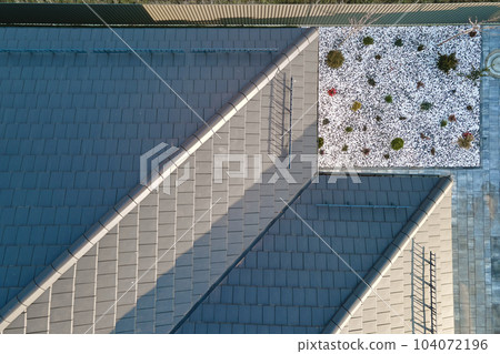 Closeup of house roof top covered with ceramic shingles. Tiled covering of building Closeup of house roof top covered with ceramic shingles. Tiled covering of building 104072196