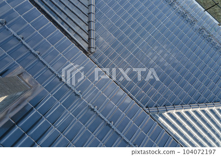 Closeup of house roof top covered with ceramic shingles. Tiled covering of building Closeup of house roof top covered with ceramic shingles. Tiled covering of building 104072197