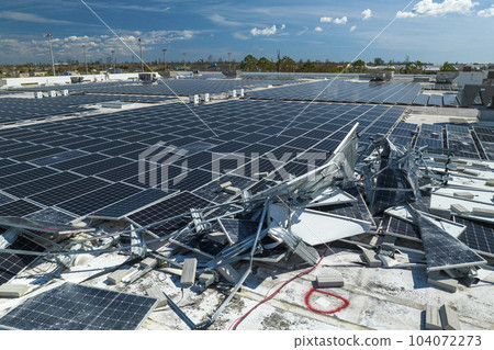 Broken down photovoltaic solar panels destroyed by hurricane Ian winds mounted on industrial building roof for producing green ecological electricity. Consequences of natural disaster Broken down photovoltaic solar panels destroyed by hurricane Ian winds mounted on industrial building roof for producing green ecological electricity. Consequences of natural disaster 104072273