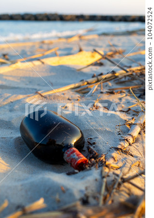 傍晚遺棄在沙灘上的酒瓶 104072524