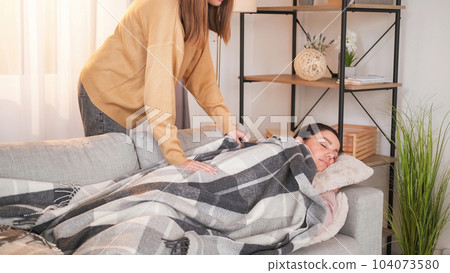 Napping time. Daughter care. Loving girl covering plaid mother sleeping on sofa weekend drowsing in light room interior. Napping time. Daughter care. Loving girl covering plaid mother sleeping on sofa weekend drowsing in light room interior. 104073580