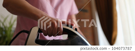 Woman ironing clothes on board at home closeup 104073787