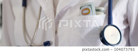 Medical doctor woman with hundred dollar bills in pocket closeup 104073793