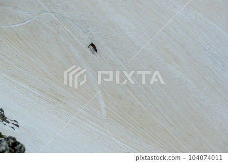 A snowboarder gliding down Kenzawa 104074011