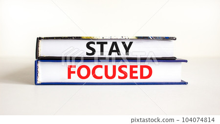 Stay focused symbol. Concept words Stay focused on beautiful books on a beautiful white table white background. Business, support, motivation, psychological and stay focused concept. Copy space. 104074814