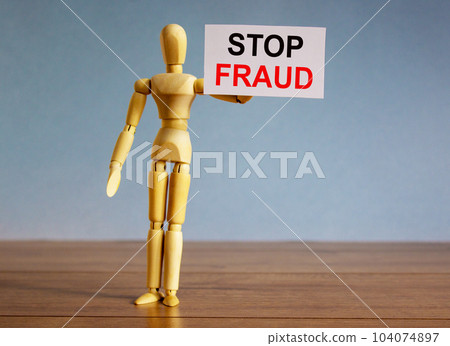 Wooden model of a man holding a tablet saying 'stop fraud'. Wooden model of a man holding a tablet saying 'stop fraud'. 104074897